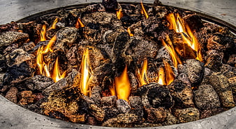 Close-up of burning charcoal and flames in a metal fire pit