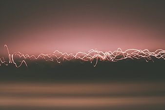 Abstract Electric Light Trails Against Muted Sunset Sky