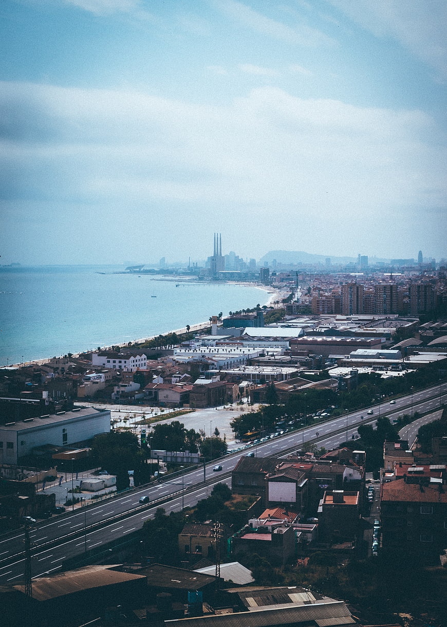 Aerial view of Barcelona coastline with industrial skyline and highway