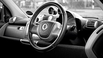 Black and white car interior with steering wheel and dashboard