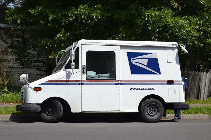 White USPS Mail Delivery Truck Parked On Suburban Street