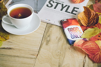 Autumn flat lay with tea, magazine, and smartphone on wood