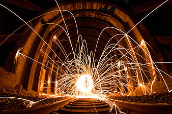 Steel wool sparks in abandoned railway tunnel at night