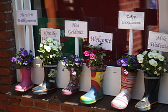 Colorful Rubber Boots With Flowers And Multilingual Welcome Signs