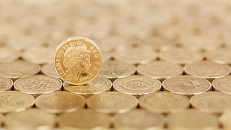 Close-up of British Pound Coins with One Standing Upright