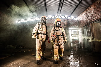 Two Firefighters in Full Gear Standing in Smoky Burnt Building