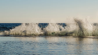 Powerful ocean wave crashing with spray and sea foam