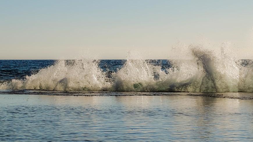 Powerful ocean wave crashing with spray and sea foam