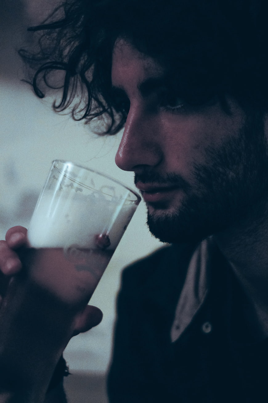 Moody Portrait of Man Drinking Beer at Night