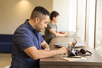 Man working on tablet in modern office with colleague