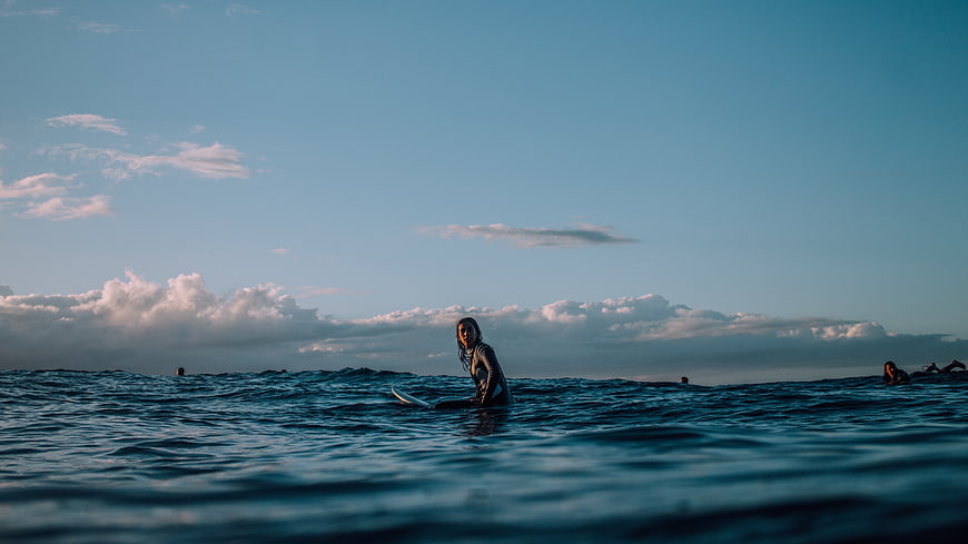 Surfer in Ocean with Blue Sky and Clouds