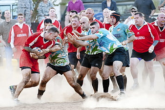 Muddy Rugby Players Tackling in Dusty Match