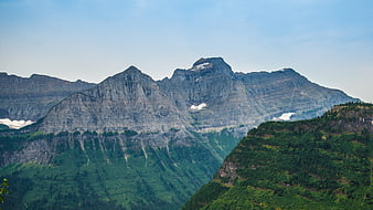 Majestic Rocky Mountain Peaks with Green Forested Slopes