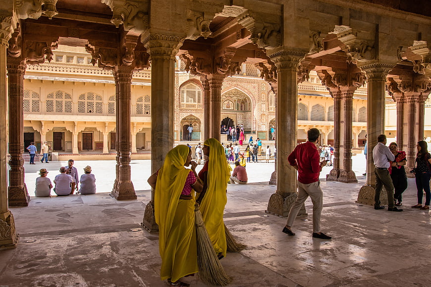 Women in Yellow Sarees Sweeping Historic Jaipur Palace Courtyard