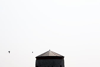 Minimalist Architecture: Stone Tower Top Against White Sky