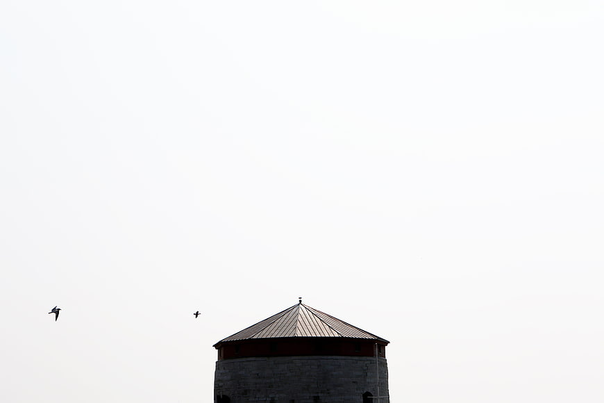 Minimalist Architecture: Stone Tower Top Against White Sky