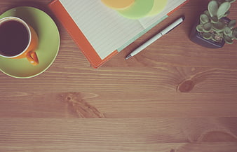 Flat Lay of Coffee Cup, Notebook, and Pen on Wooden Desk