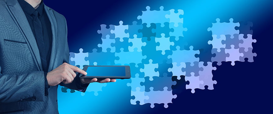 Businessman Using Tablet With Digital Puzzle Pieces Background