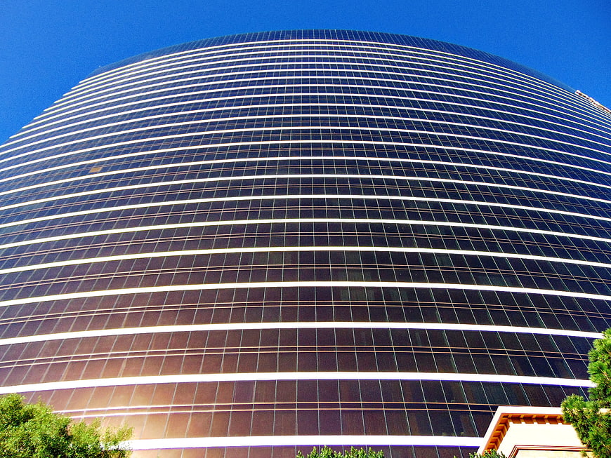 Low angle view of modern curved glass skyscraper facade