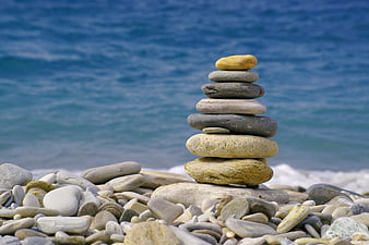 Stacked Beach Pebbles Against Blue Sea Background