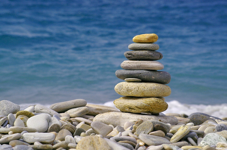 Stacked Beach Pebbles Against Blue Sea Background