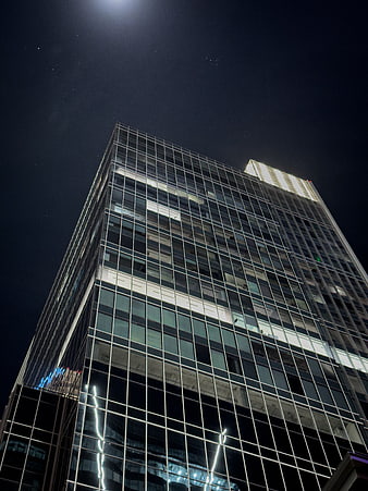 Low angle view of modern glass skyscraper at night
