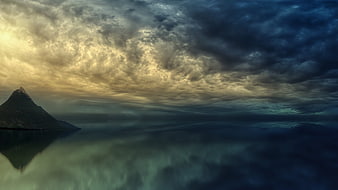 Dramatic Mountain Peak Reflection in Calm Water at Dusk