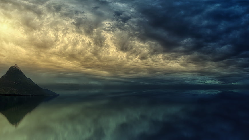 Dramatic Mountain Peak Reflection in Calm Water at Dusk