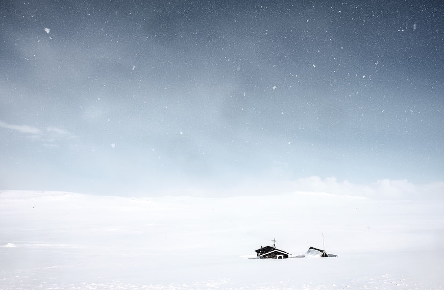 Snowy Landscape with Cabin and Falling Snowflakes