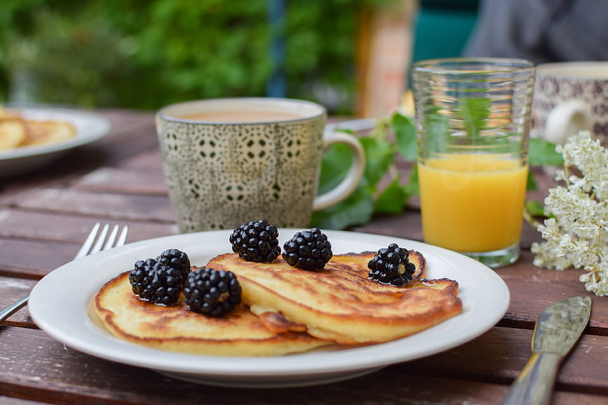 Fresh Pancakes With Blackberries And Orange Juice On Wooden Table