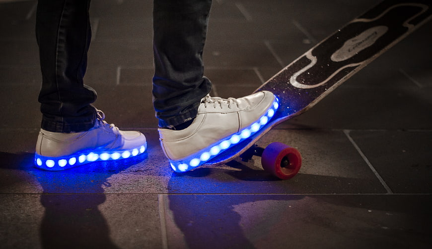 Person with LED light-up shoes and skateboard at night