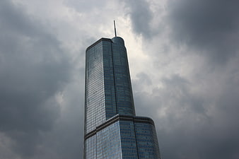 Low angle view of modern skyscraper against dramatic cloudy sky