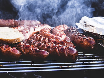 Grilled Sausages and Bread on a Smoky Barbecue Grill