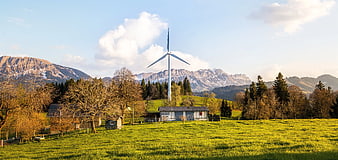 Wind Turbine in Alpine Meadow with Mountains