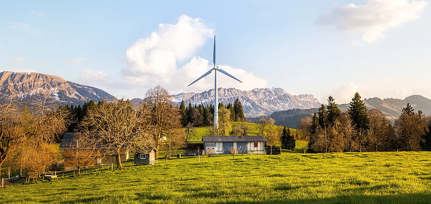 Wind Turbine in Alpine Meadow with Mountains