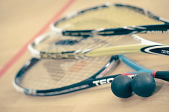 Squash rackets and balls on indoor court floor