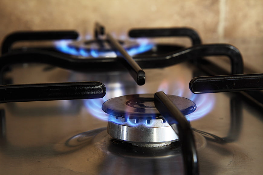 Close-up of lit gas stove burners with blue flames