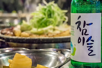 Korean Soju Bottle And Steaming Food Spread