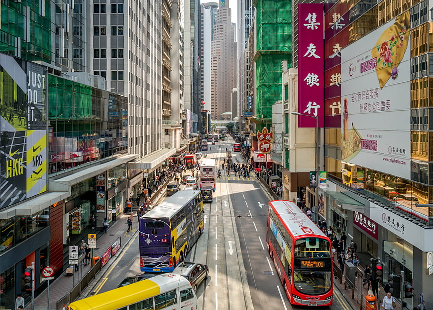 Busy Hong Kong Street with Double-Decker Buses and Skyscrapers