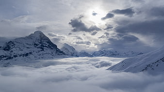 Snowy Mountain Peaks Rising Above Sea of Clouds