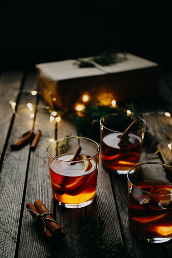Warm mulled wine with cinnamon and orange on rustic wood
