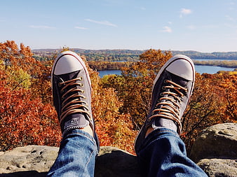 First-person view of sneakers overlooking autumn landscape