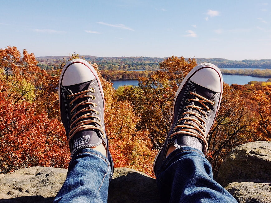 First-person view of sneakers overlooking autumn landscape