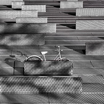 Black and white bicycle parked against textured metal wall