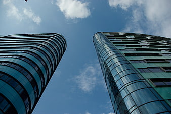 Low angle view of modern glass skyscrapers against blue sky