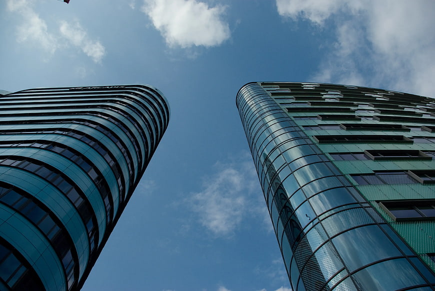 Low angle view of modern glass skyscrapers against blue sky