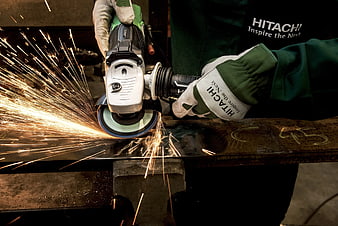 Worker using angle grinder with sparks flying