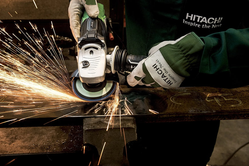 Worker using angle grinder with sparks flying
