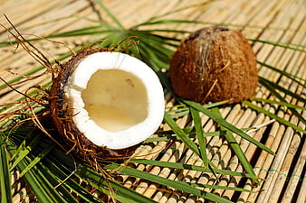 Fresh Coconut with Water on Bamboo Mat