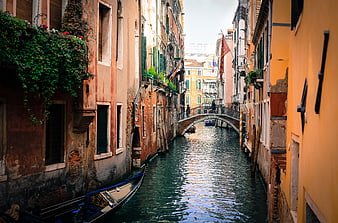 Narrow Venice Canal with Gondola and Arched Bridge